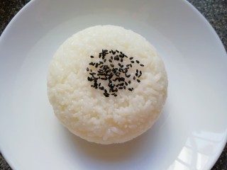 咖喱鸡肉饭, 将蒸好的米饭盛在小碗里压实，然后倒扣在盘子里，撒上一些黑芝麻。