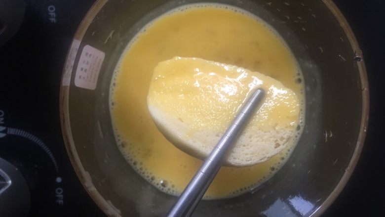 香烤馒头片,4️⃣ 馒头片放入鸡蛋液中，均匀裹上鸡蛋液。