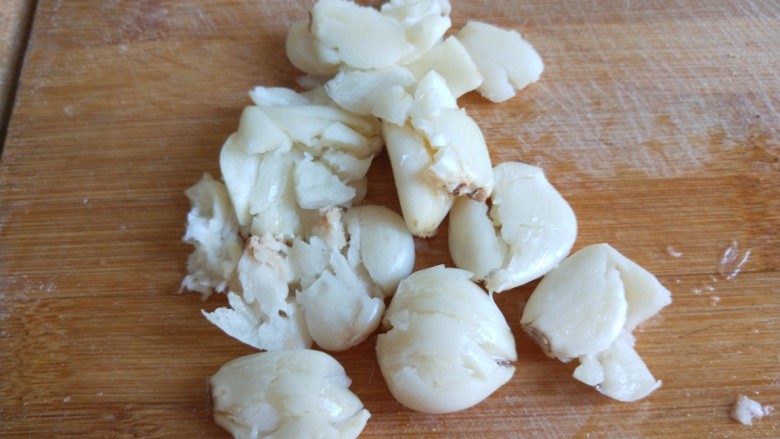 新文美食  五花肉耗油豆角焖面,这会儿的时候把大蒜拍扁剁碎。