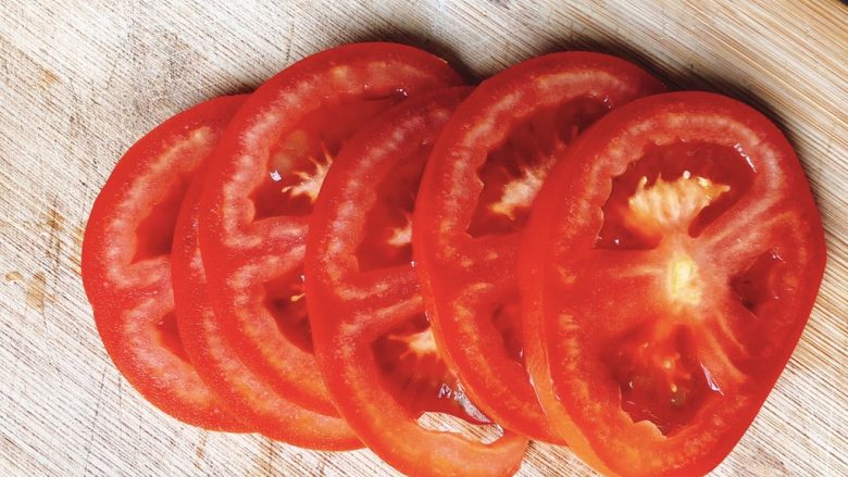 西红柿（番茄）花蛋饼-宝宝辅食,头尾切去，中间部分切成0.5厘米厚的西红柿片。