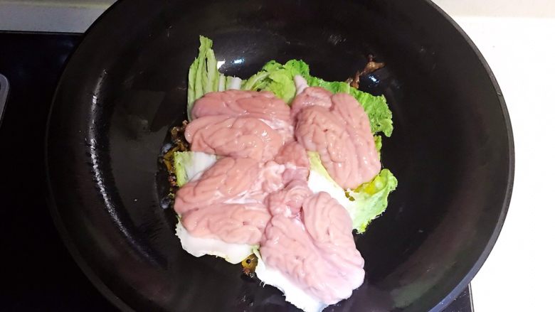 香辣脑花面,锅底放入2个白菜叶防止粘锅，在白菜叶上面放入猪脑