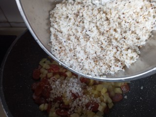 电饭锅土豆腊肠焖米饭,放入淘好的米翻炒均匀