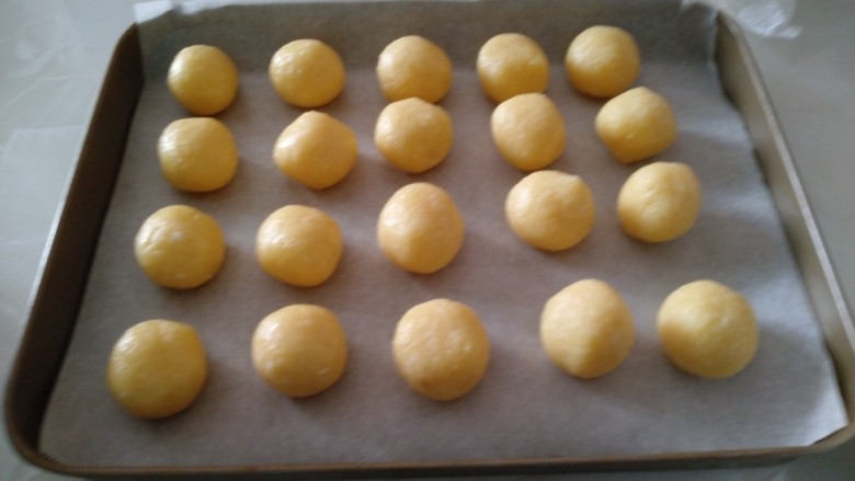 黄金椰蓉酥,大约分成12克的小面团，用手搓成小球，外面刷一层全蛋液。