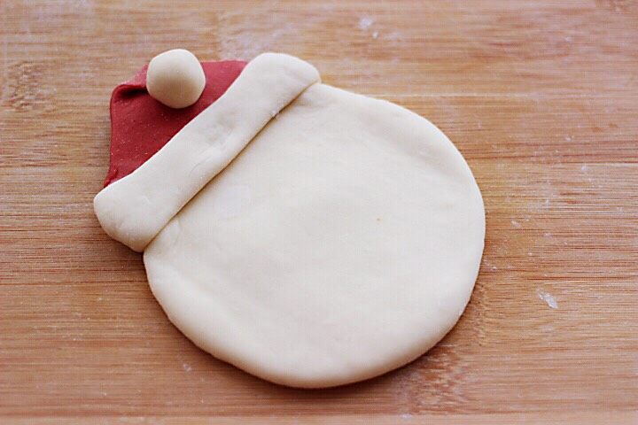 十味  萌萌哒的圣诞老人馒头,把帽子的尖角折过来，上面放上做好的白色面团。如图