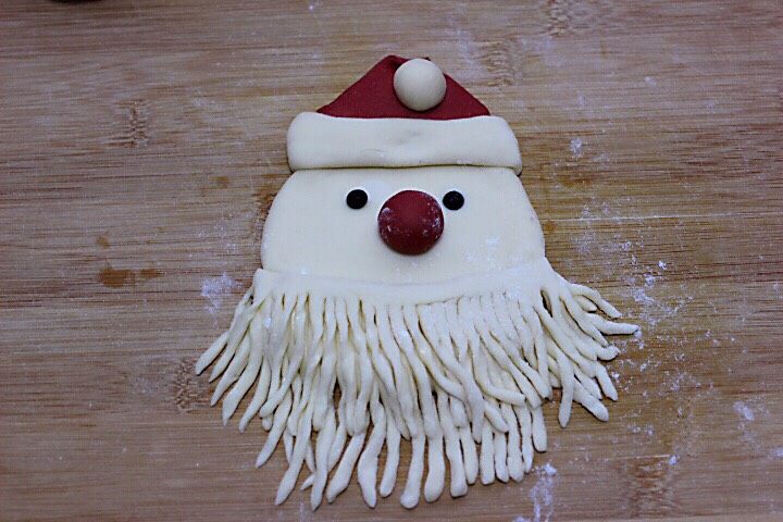十味  萌萌哒的圣诞老人馒头,把做好的胡须放在脸部的下方、整理一下胡须、嘻嘻、圣诞老人就做好了。