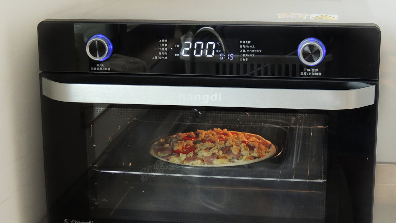 香菇培根披萨,烤箱设置上下火温度200度，时间15分钟，预热完成以后，将披萨放入烤箱中。