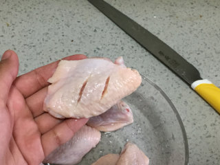 柠檬咖喱鸡翅,3、之后，把鸡翅捞出，用刀子在鸡翅的表面划上两道。
