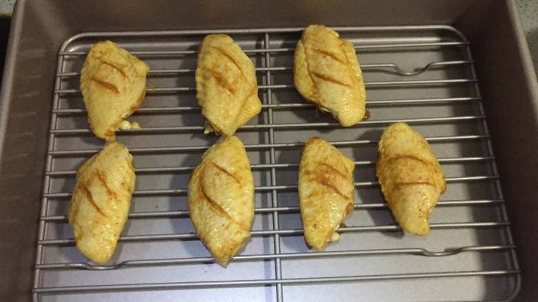 柠檬咖喱鸡翅,6、接着，取出腌制好的鸡翅，放在烤盘上，同时把烤箱预热。
