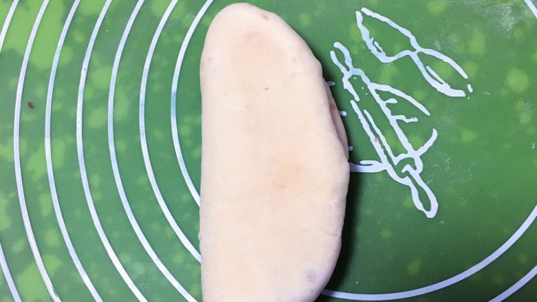 红豆心形面包,再将剂子擀成椭圆形，两边折叠。