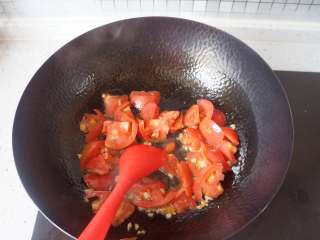 番茄肥牛刀削面,热锅热油放入姜蒜炒香，放入番茄翻炒