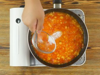 快手番茄疙瘩汤,炒锅倒油烧热，放入葱花、蒜末爆香，再放入西红柿丁炒至软烂，而后倒入适量热水煮沸
