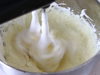 奶香浓郁牛轧糖（熬糖版），越嚼越香,倒入奶粉，打蛋器搅打让奶粉融入到糖中，这里需要注意，打蛋器功率至少200W才可以，否则打蛋器容易烧坏，如果不用打蛋器的话，这步，就直接用硬质的刮刀，翻拌。