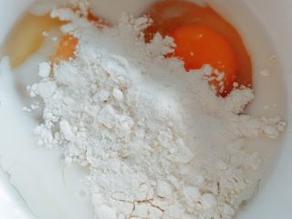 紫薯鸡蛋卷,碗中打入两颗鸡蛋 加入牛奶 面粉
