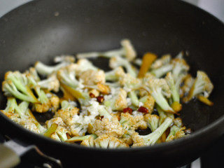 干煸菜花,加入蒜沫和干辣椒，继续翻炒