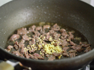 黑椒牛肉杏鲍菇,快速划炒至牛肉变色后放入姜末炒匀