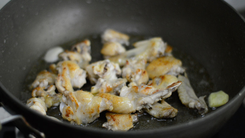 酱烧土豆鸡翅,煎至两面焦黄后放入姜蒜，翻炒出香味
