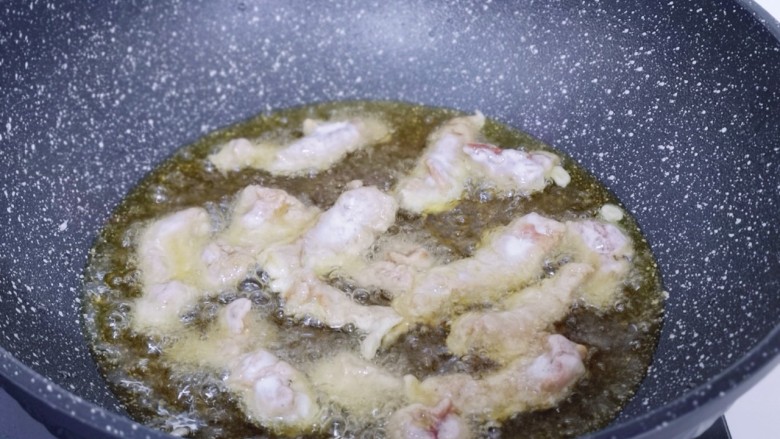 葱香椒盐小酥肉,起油锅，油温8成时将裹满面糊的肉条放入油锅中。
