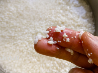 糯米红豆糕,浸泡后的糯米用手指一捻就碎的状态，这种状态的糯米就是泡好了。