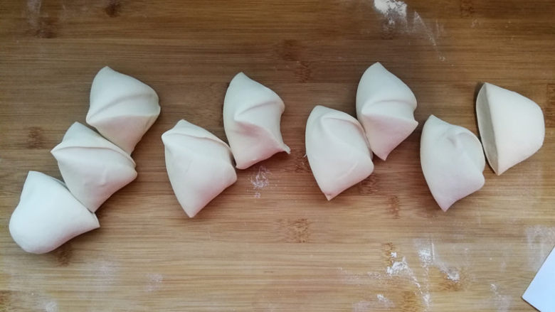 韭菜鸡蛋馅儿包子,发酵好的面团取出，案板上撒干面粉，将面团揉压排气。重新揉光滑搓长，分成8份。