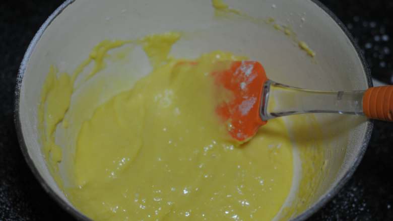 金秋蛋糕,蛋黄糊里筛入低粉，用刮刀翻拌成均匀的蛋糕糊。