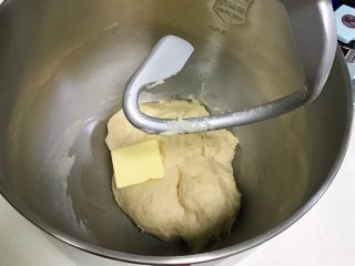 红曲双色椰浆面包,可以拉出厚膜后，往搅拌桶内加入黄油。