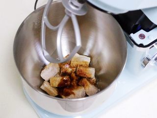 自制海苔肉松（厨师机版）,厨师机提前安上搅拌桨，趁肉温热迅速加入厨师机搅拌桶内，继续加入生抽、老抽、细砂糖和玉米油。