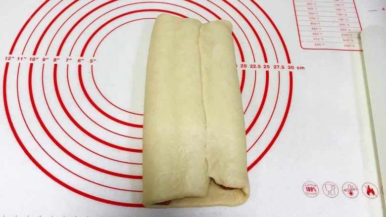 红曲双色椰浆面包,剩下右边的白色面片往左边折过来，捏紧收口。