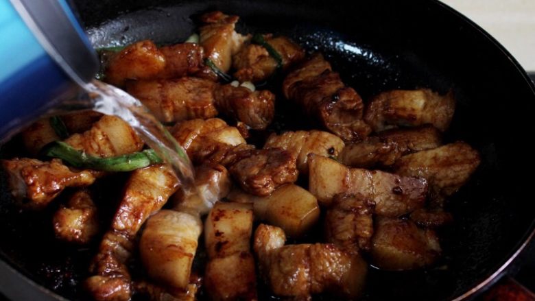 十味 红烧肉豆腐泡,翻炒至酱油均匀上色，倒入开水，漫过肉。