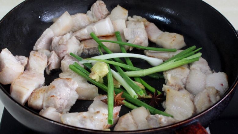 十味 红烧肉豆腐泡,锅里不放油，用中小火将肉炒至微微上色，然后将葱，姜、八角和红糖放入锅中炒。