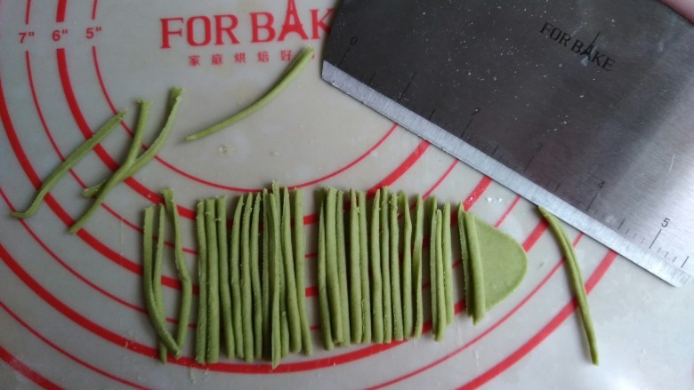象形胡萝卜馒头,绿色面团擀成薄面片，用法焙客切面刀切出若干条细小的面条。