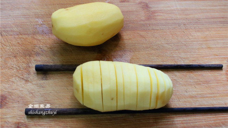 香烤风琴土豆,<a style='color:red;display:inline-block;' href='/shicai/ 23'>土豆</a>去皮洗净，切成0.5cm的片，底部不要切断，切的时候可把底部垫两根筷子，这样可防止切断；