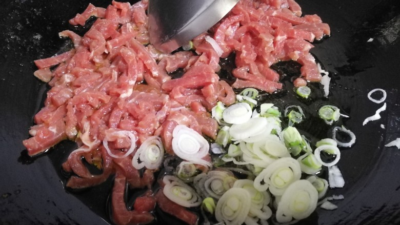 家常菜~牛肉炒大青椒,放入葱片，牛肉条。