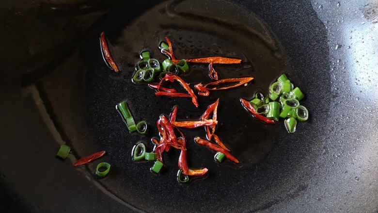 十味 双椒爆双耳,锅中适量油烧至7成热，下入葱花和干辣椒爆出香味。