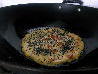 十味  番茄鸡蛋饼,热锅中加入适量油，倒入面糊，上面撒黑芝麻，表面凝固，底煎金黄后翻面。