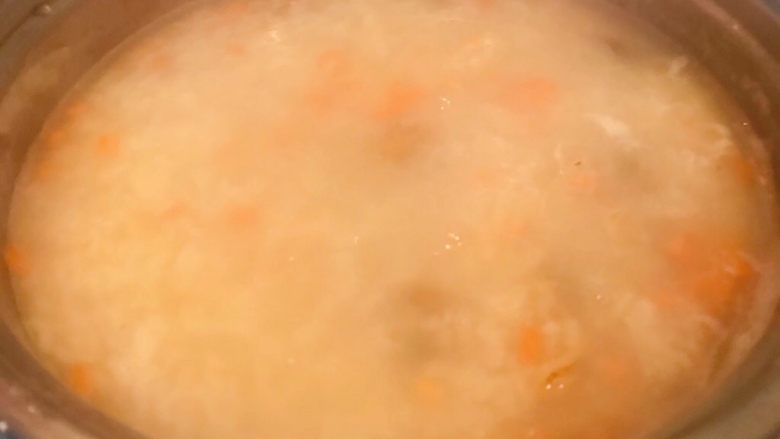 扇贝茼蒿胡萝卜米粥,放入胡萝卜煮2分钟
