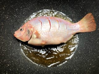 红烧鱼,锅里放入适量油烧热，放入腌制好的鱼煎制，不要马上翻面，煎3分钟再翻面。