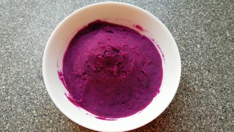 紫薯馅老婆饼,蒸好的紫薯趁热用勺子压成紫薯泥。