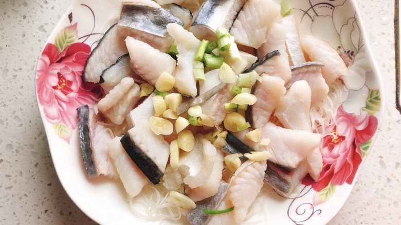 剁椒粉丝巴沙鱼-若是龙利鱼这么做也很好吃,将蒜头和葱白撒到鱼片上。