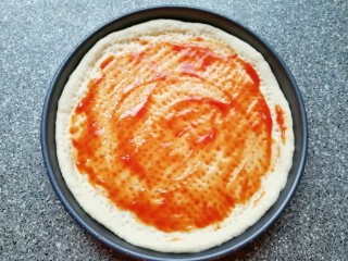 火腿肠披萨,在饼底上涂一层番茄酱。
烤箱上下管200度预热。