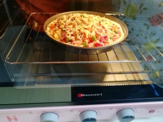 火腿肠披萨,送入预热好的烤箱中层，上下管200度烤20分钟。
