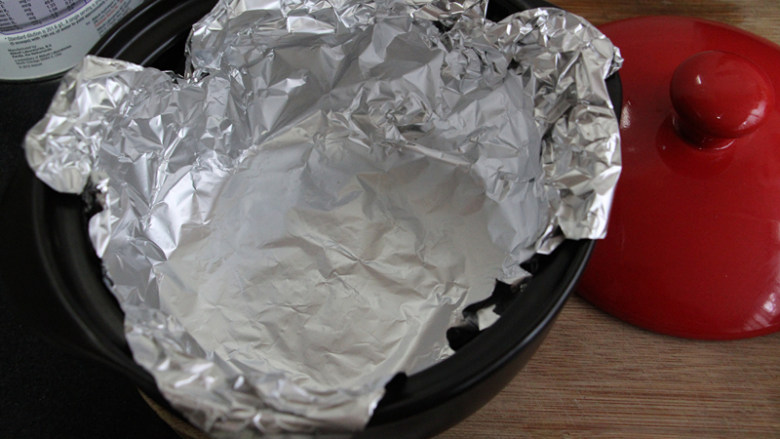 黑乐砂锅烤板栗,将锡纸铺在砂锅里。