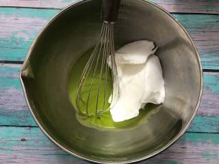 菠菜蛋糕卷,取三分之一的蛋白霜到蛋黄糊中，用翻拌的手法搅拌均匀。