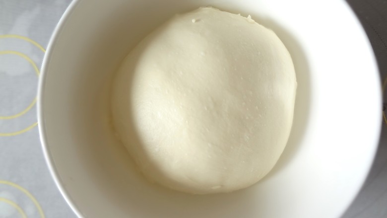 辫子酥粒面包,取出面团整理成光滑的面团放入发酵碗中盖上保鲜膜开始一发，室温发酵一个小时，具体时间要根据温度和面团的状态决定