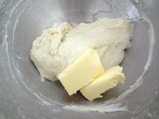 辫子酥粒面包,加入软化好的黄油开始启动低速搅打，黄油混合进去后高速搅打至黄油完全混合