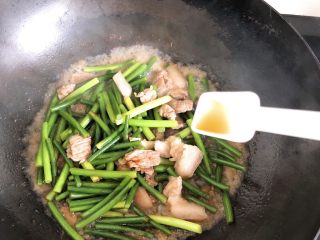 蒜苔炒肉-下饭菜,加入1勺料酒，翻炒后，再盖上锅盖焖3～5分钟。