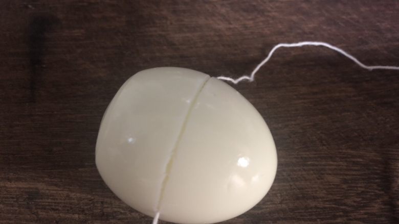 茭白虎皮蛋,用干净的棉线将鸡蛋切开。
