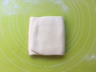 双色牛角酥,将面片折成3折，之后包裹上油纸，装入保鲜袋冰箱冷冻15分钟 