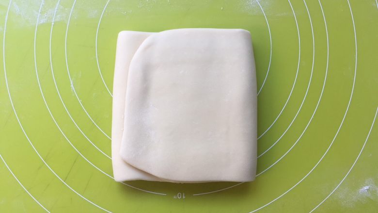 双色牛角酥,将面片折成3折，之后包裹上油纸，装入保鲜袋冰箱冷冻15分钟 