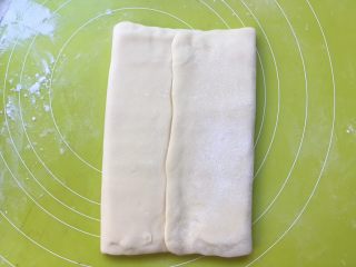 双色牛角酥,将两侧的面片折叠过来，包裹上黄油片，黄油片一定要包裹严实，免得擀的时候跑油 