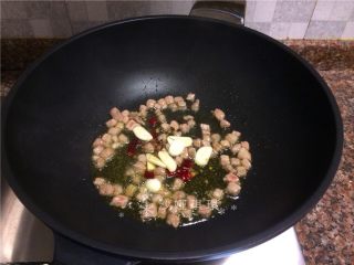 十味 泡豇豆炒牛肉粒,放入花椒、大蒜和干辣椒段翻炒出香味。
